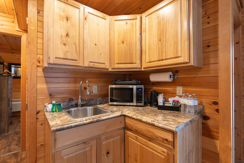 compact kitchen corner with wooden cabinets and granite countertops