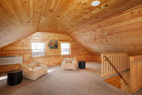 Cozy loft space with wood-paneled walls and comfortable seating for relaxation.