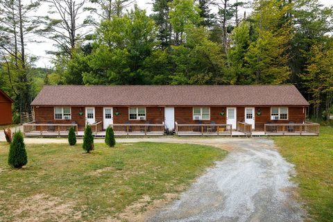 rustic cabin units with private porches set against a forest backdrop