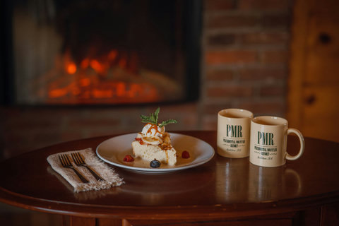 Cozy dessert and coffee setup by the fireplace at the presidential mountain resort.