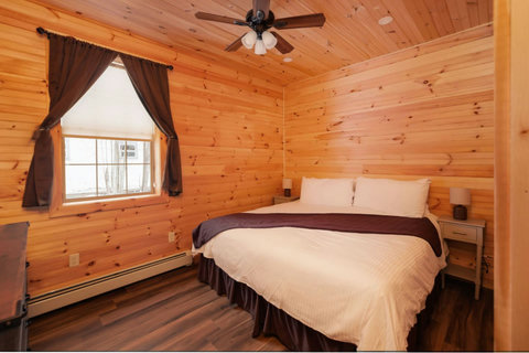 Cozy bedroom with wood-paneled walls and a king-size bed for a restful stay.