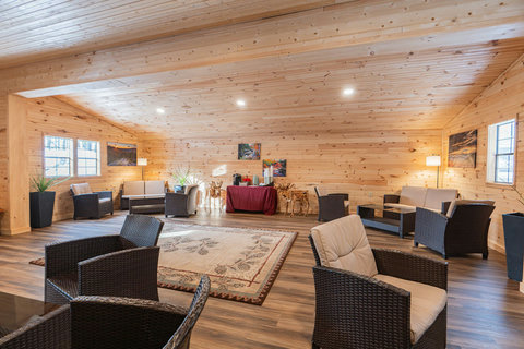 Spacious rustic lounge area with comfortable wicker seating and natural wood paneling.