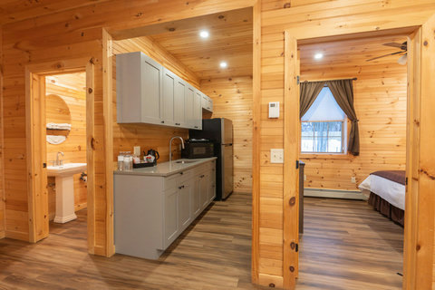 Cozy cabin kitchen with modern cabinetry and views into the bedroom and bathroom.