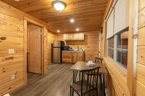 Cozy kitchen and dining area with wood-paneled walls and modern appliances.
