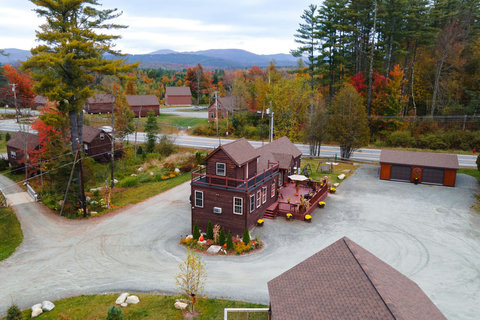 Rustic cabin with a spacious deck surrounded by autumn foliage and mountain views.