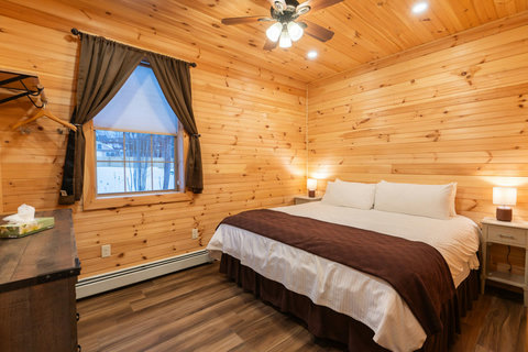 Cozy bedroom with wood-paneled walls and a king-size bed for a restful stay.
