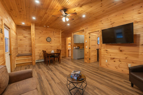 Spacious living area with wood-paneled walls and modern flooring for a cozy cabin experience.