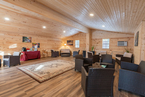 spacious lounge area with wood-paneled walls and wicker seating for group gatherings