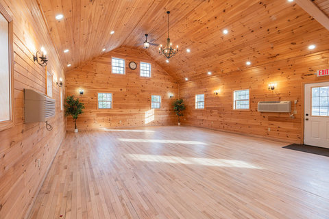 Spacious rustic hall with natural wood walls and ample natural light.