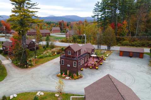 Rustic cabin with spacious outdoor deck surrounded by autumn foliage and mountain views