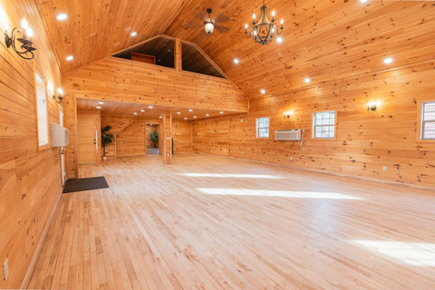 spacious rustic hall with wood-paneled walls and natural light