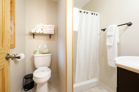 Compact bathroom with a shower and neatly arranged towels for guest convenience.