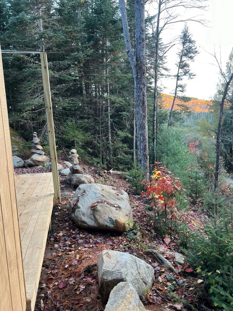 View of a forested landscape from a wooden deck on a cloudy day.