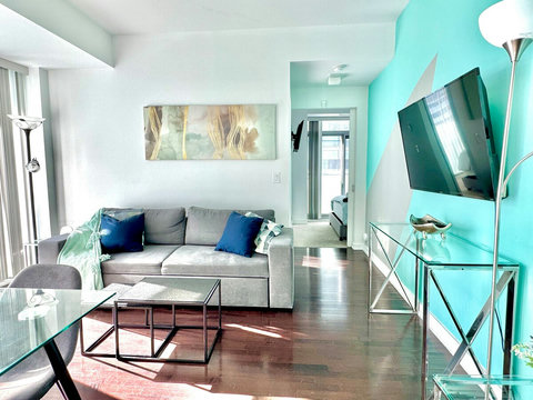 Unwind in a spacious living room with a cozy couch, 42” Smart TV, blazing-fast Wi-Fi, and breathtaking CN Tower views. Perfect for streaming, relaxing, or enjoying the stunning city skyline morning to night in total comfort and style.