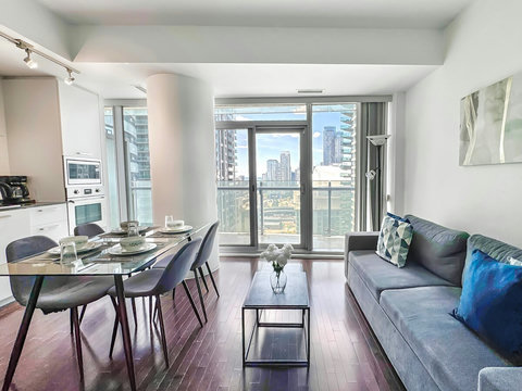 Unwind in a spacious living room with a cozy couch, 42” Smart TV, blazing-fast Wi-Fi, and breathtaking CN Tower views. Perfect for streaming, relaxing, or enjoying the stunning city skyline morning to night in total comfort and style.
