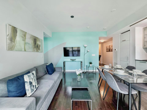 Unwind in a spacious living room with a cozy couch, 42” Smart TV, blazing-fast Wi-Fi, and breathtaking CN Tower views. Perfect for streaming, relaxing, or enjoying the stunning city skyline morning to night in total comfort and style.