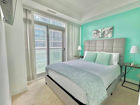 Rest and recharge in a serene bedroom featuring a plush queen-size bed, soft linens, ample storage, a Smart TV, and a private full-size bathroom. Enjoy the perfect blend of comfort, entertainment, and privacy in your own peaceful retreat.