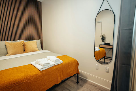 Stylish bedroom with a full-length mirror and a comfortable queen bed. A perfect space to relax and get ready for your Toronto adventures