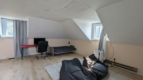 A spacious upstairs room that blends a game room and home office, complete with a futon for lounging or hosting guests