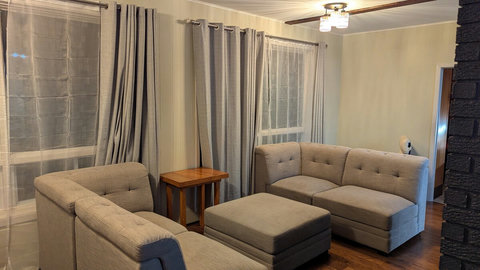 This section of the main living room features a sectional facing the river and a two-sided fireplace.
