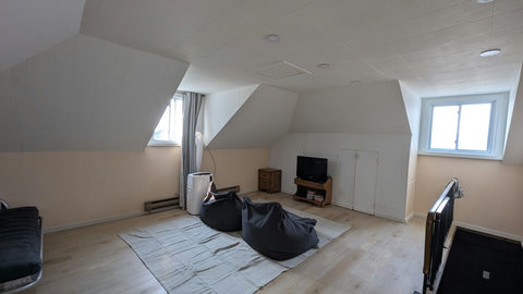 A spacious upstairs room that blends a game room and home office, complete with a futon for lounging or hosting guests