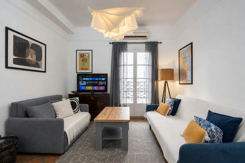 Bright living room with air conditioning, comfortable seating and direct access to the private balcony.