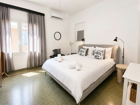 Spacious main bedroom with a king-size bed, air conditioning, ceiling fan and ample storage space.