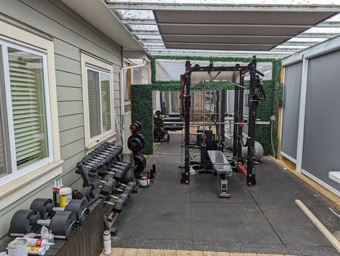 Outdoor squat rack, adjustable bench and dumbbells.  Multi-purpose area to stretch, foam roll, dance, and fitness.  